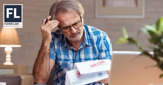 man looking at overdue bills